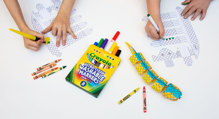 2 kids coloring The Crayola Imagine Arts Academy snake take home product with a completed version on the table